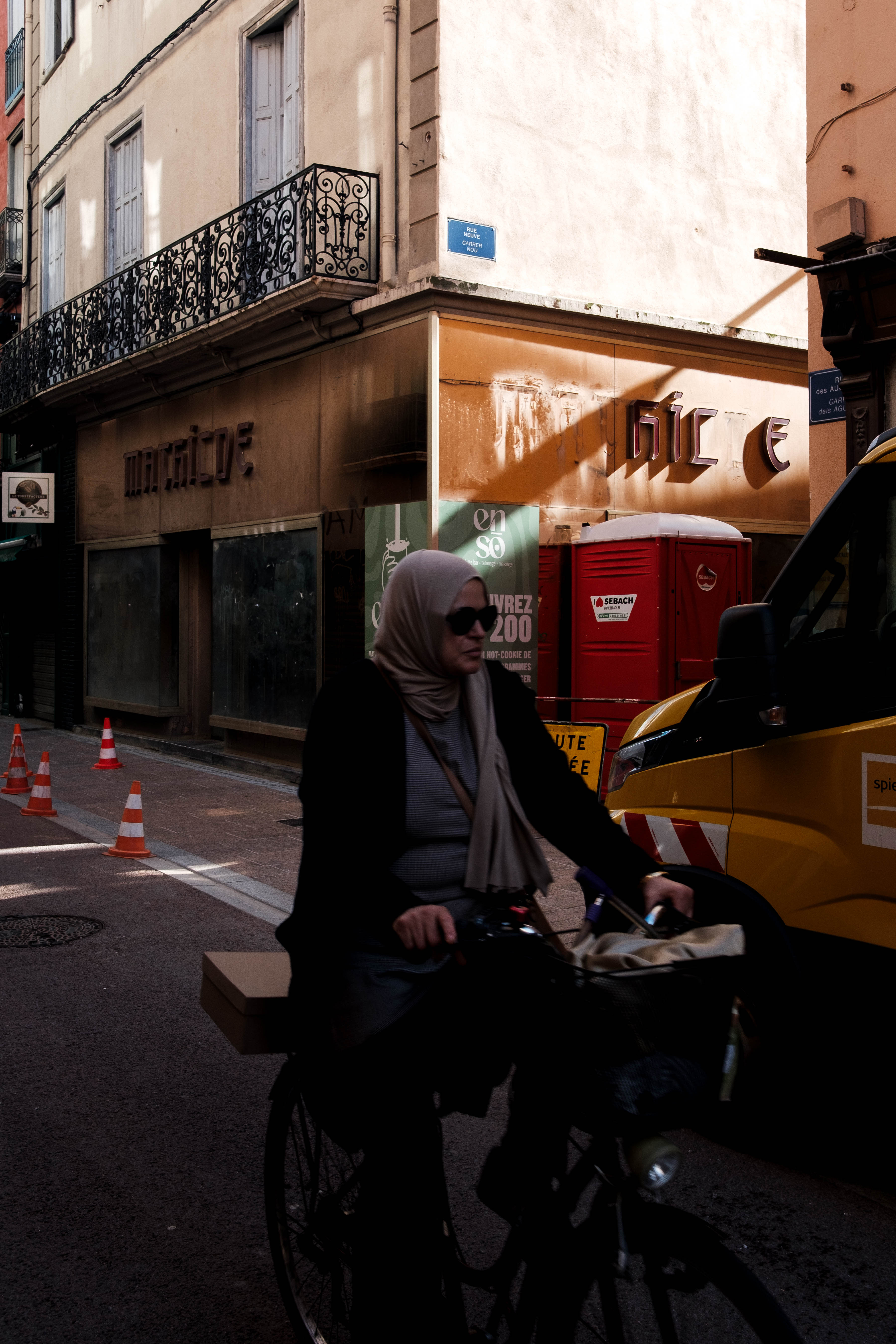 A woman rides a bike down the street