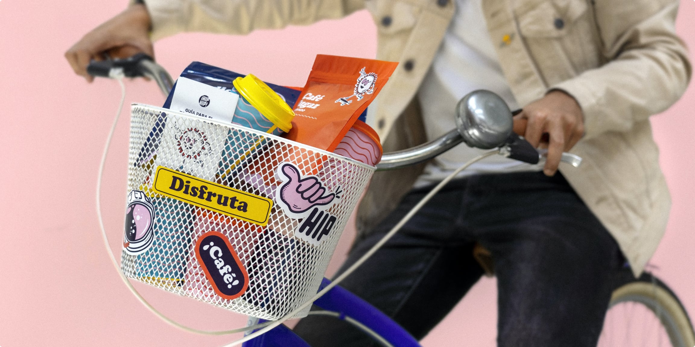 Decorative image of the torso of a man on a bicycle, with a basket that includes several products with an eye-catching packaging.