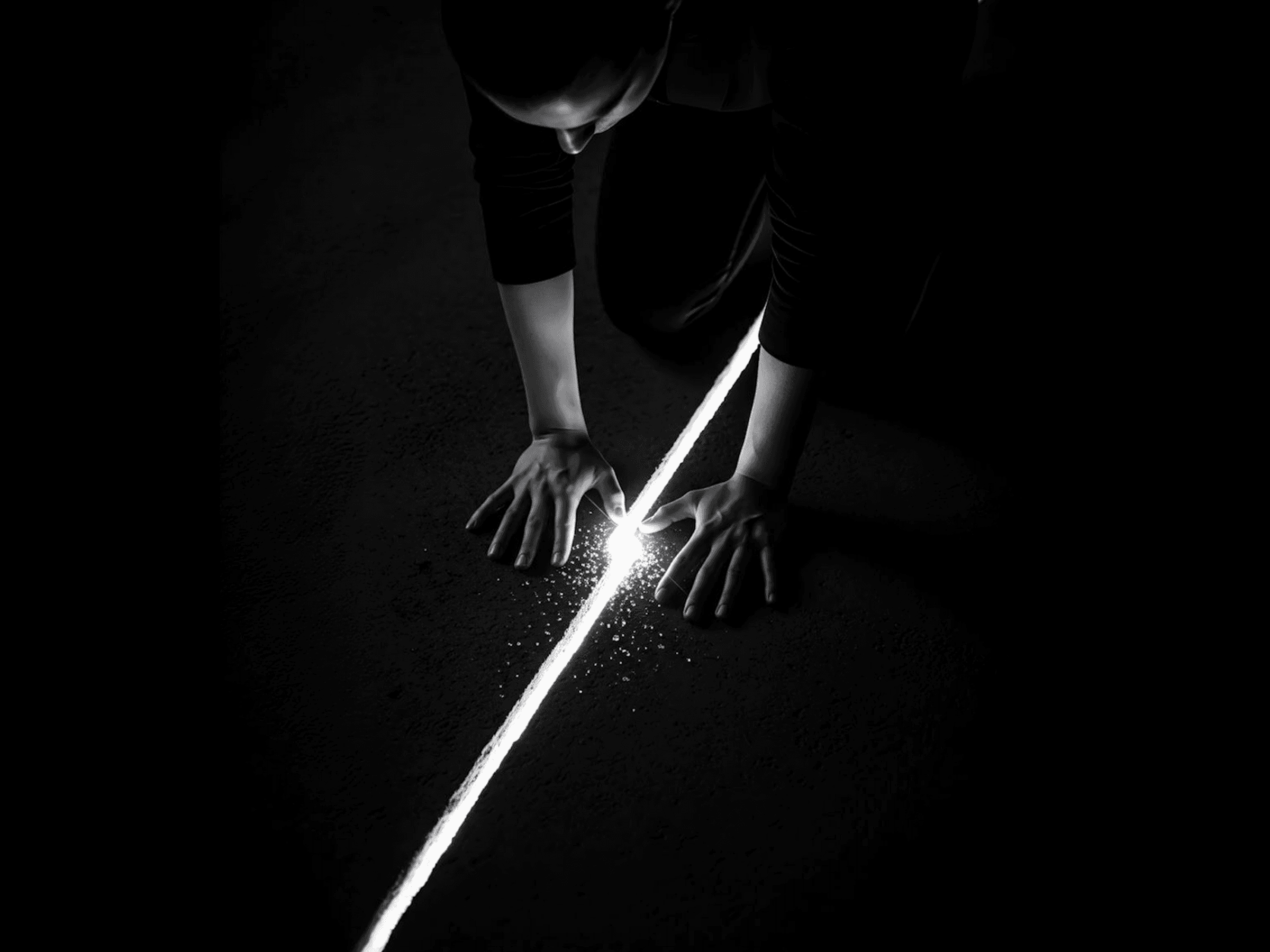 Person reaching toward beam of light on dark floor — metaphor for finding the root problem in a website redesign process