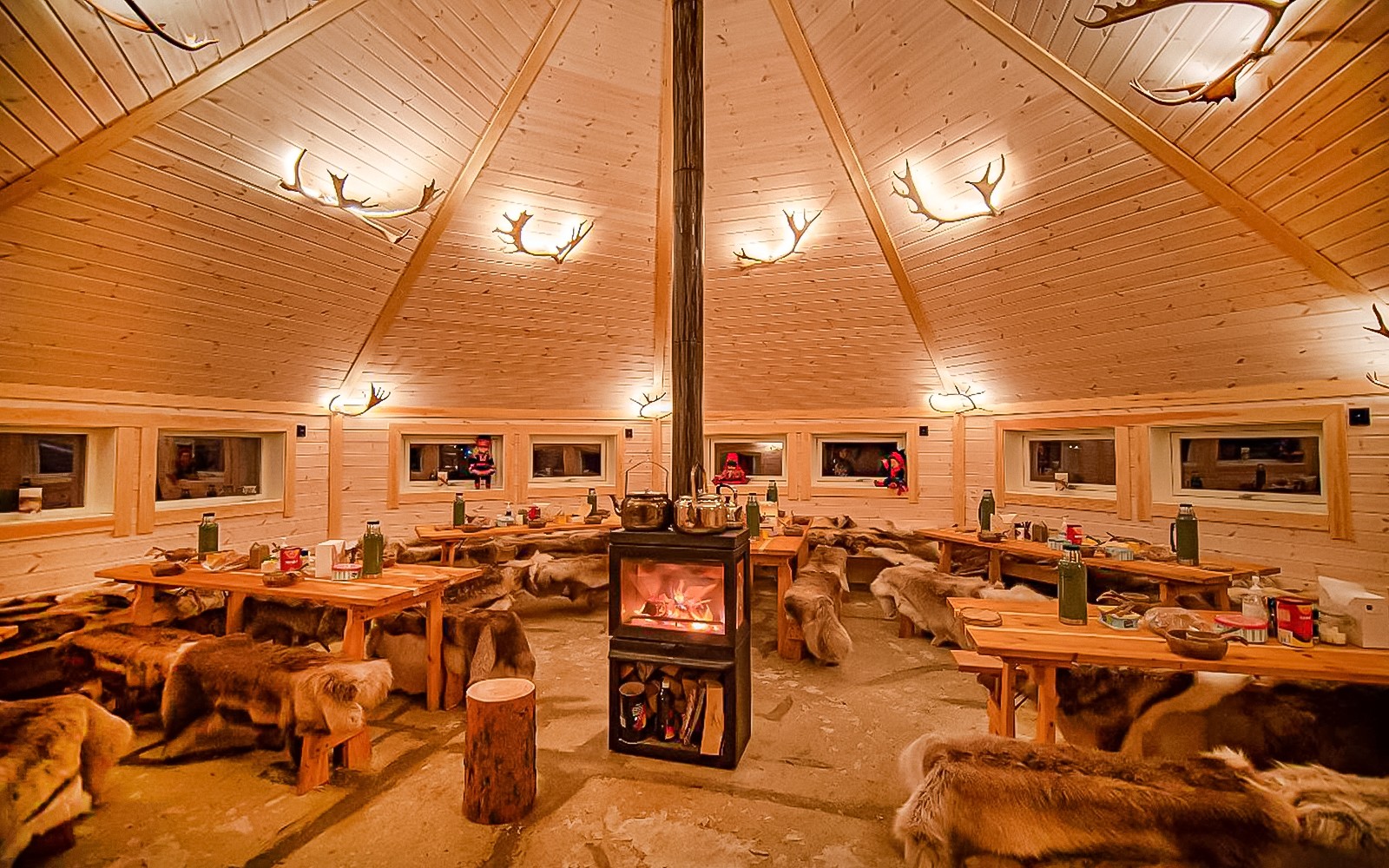 Cozy wooden cabin interior with fireplace, Tromso reindeer sledding tour.