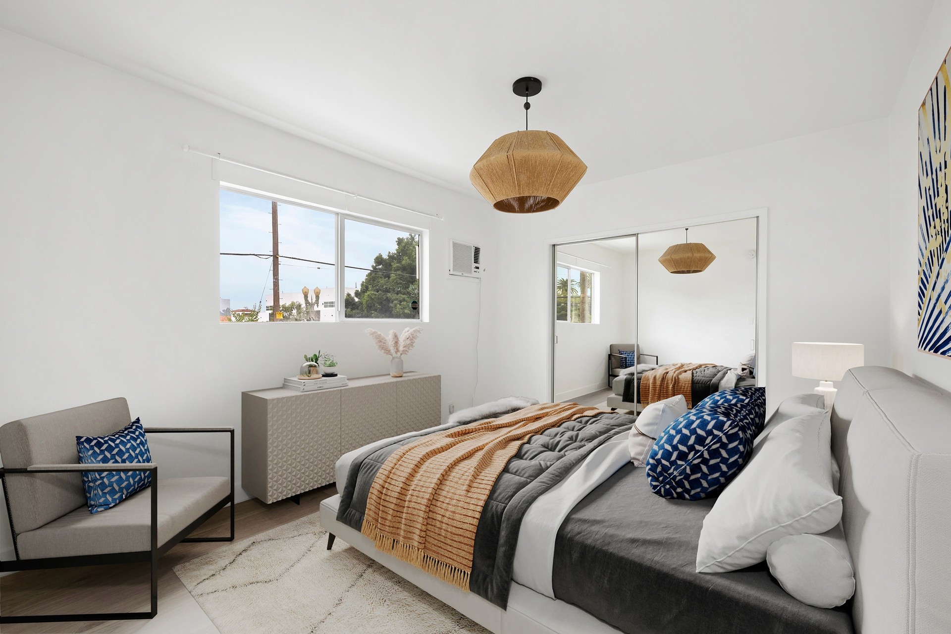 200 N Rampart staged bedroom with large window, bright walls, modern furnishings and mirrored closet.