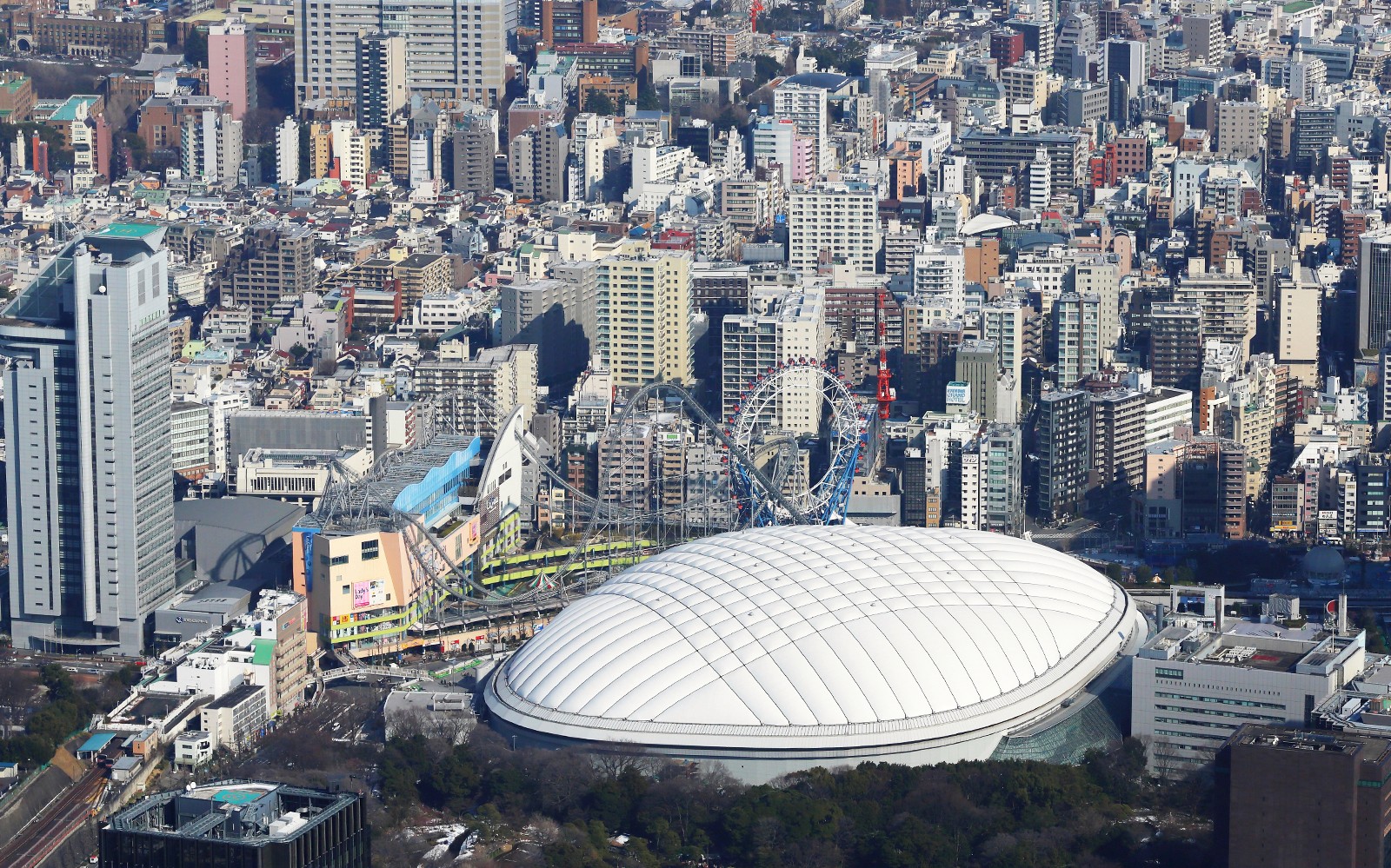 Tokyo Dome City con giostre del parco divertimenti e panorama urbano circostante.