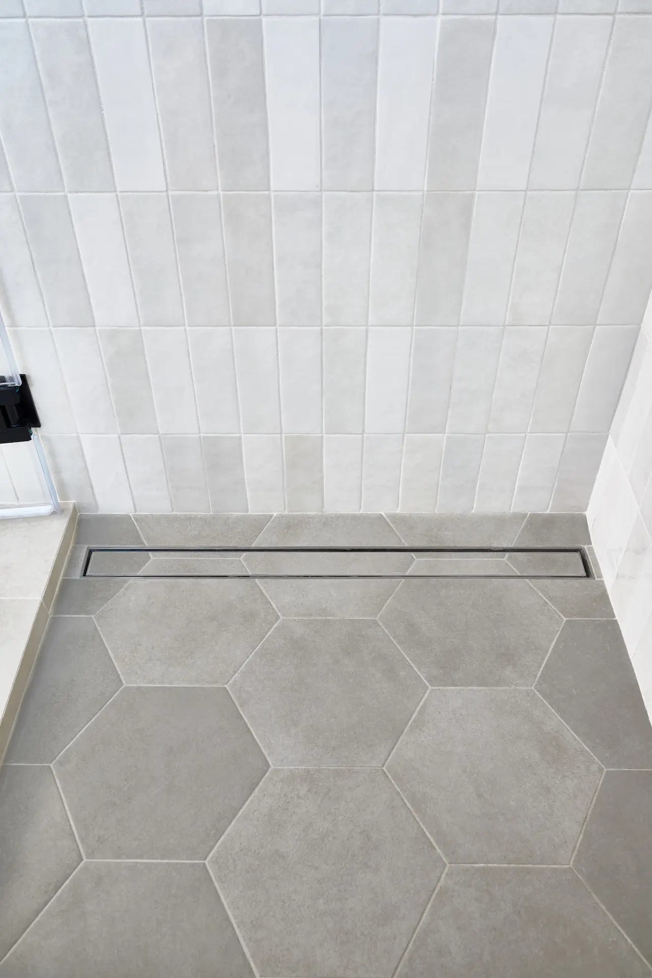 Portrait of the linear shower drain in ADU Orange, a detail that exemplifies the modern amenities within the historical context. Photo by Todd Huge.