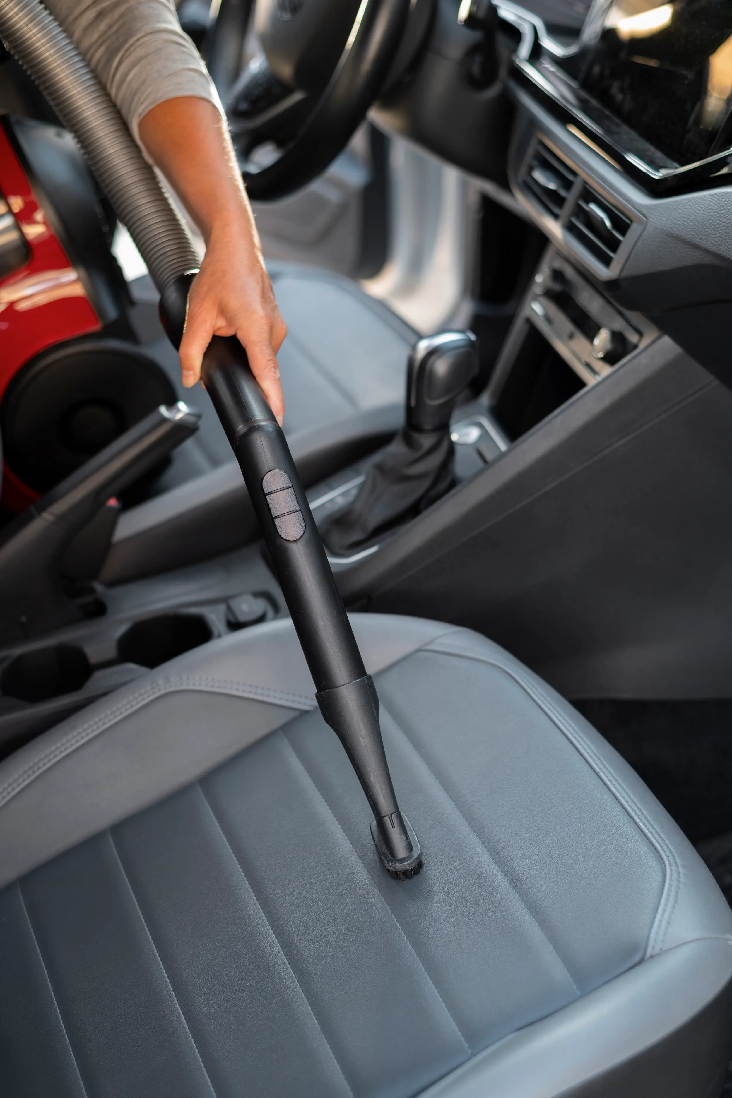 Vacumming a seat of a car by XM detailing.