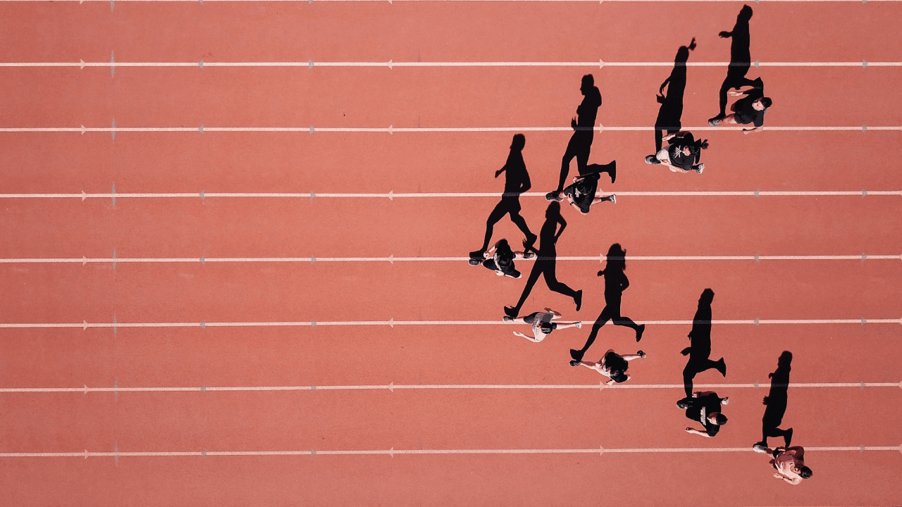 red track pavement with people running in shape of arrow