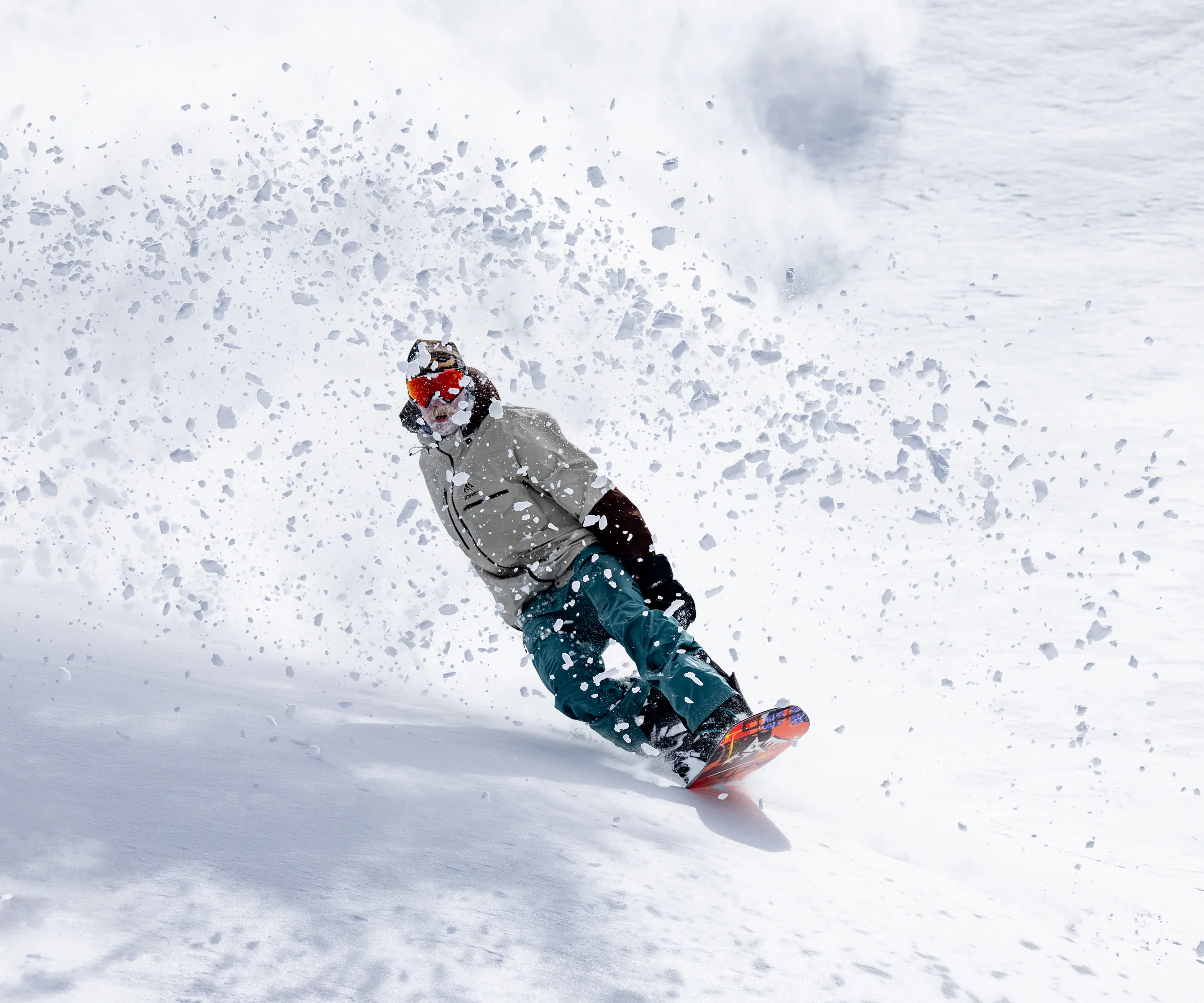 Freeride snowboarder throwing up big chunks of snow.
