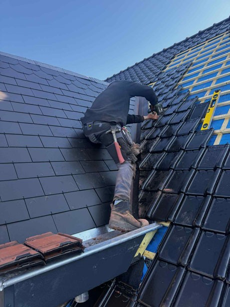 Glenn Laenens die een dak aan het dekken is