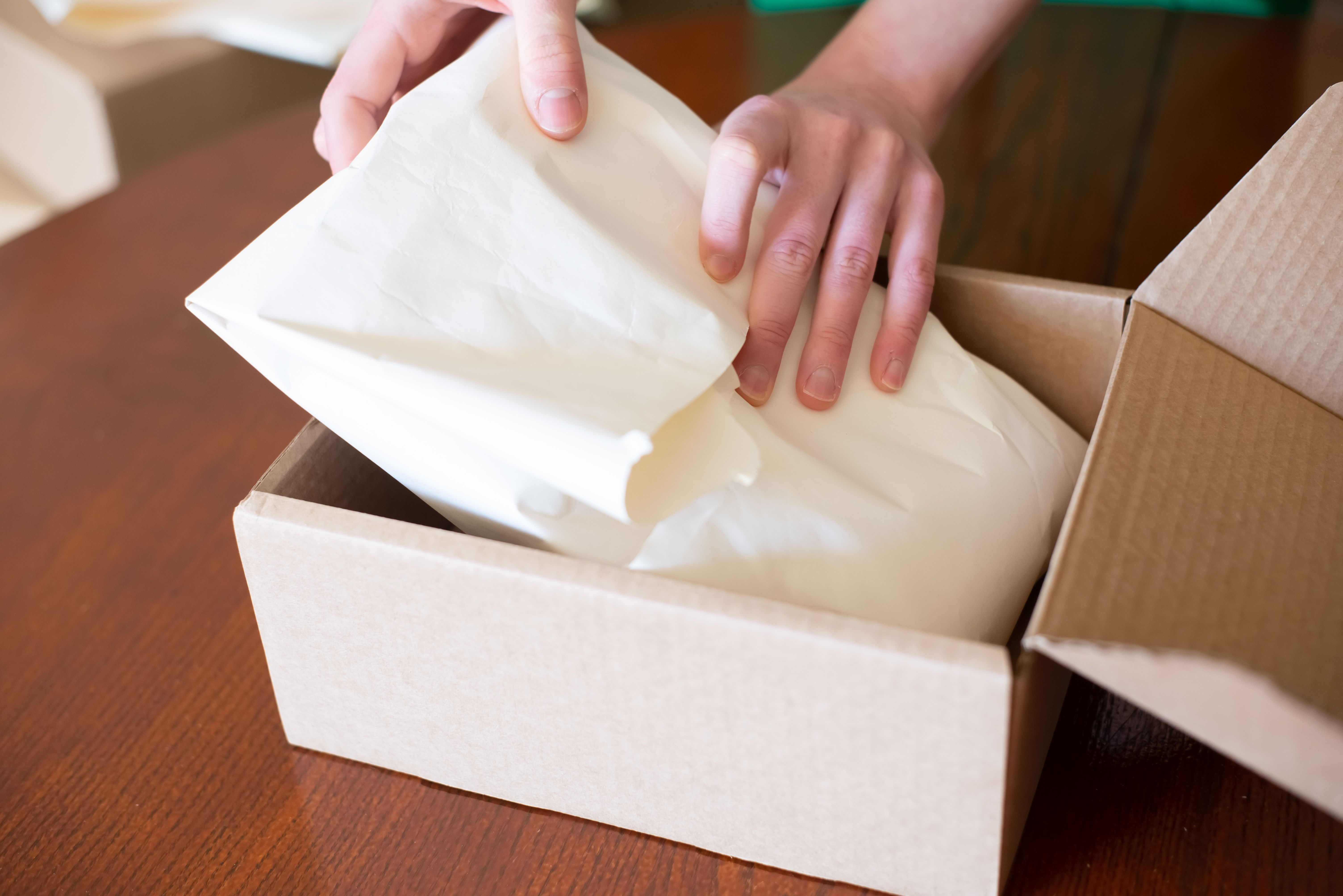 A man is packing an order with paper.
