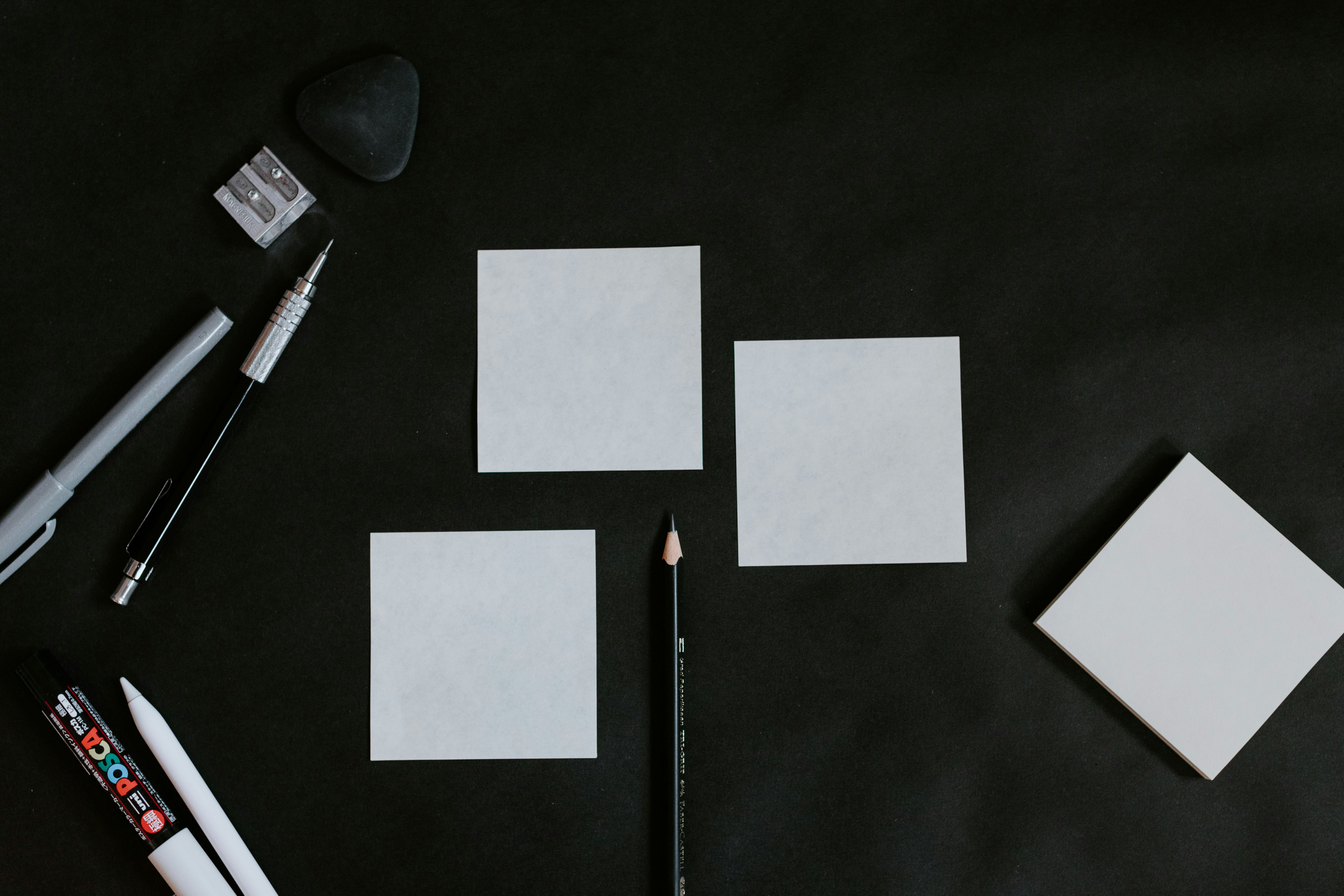 A black table topped with white cards and a pencil