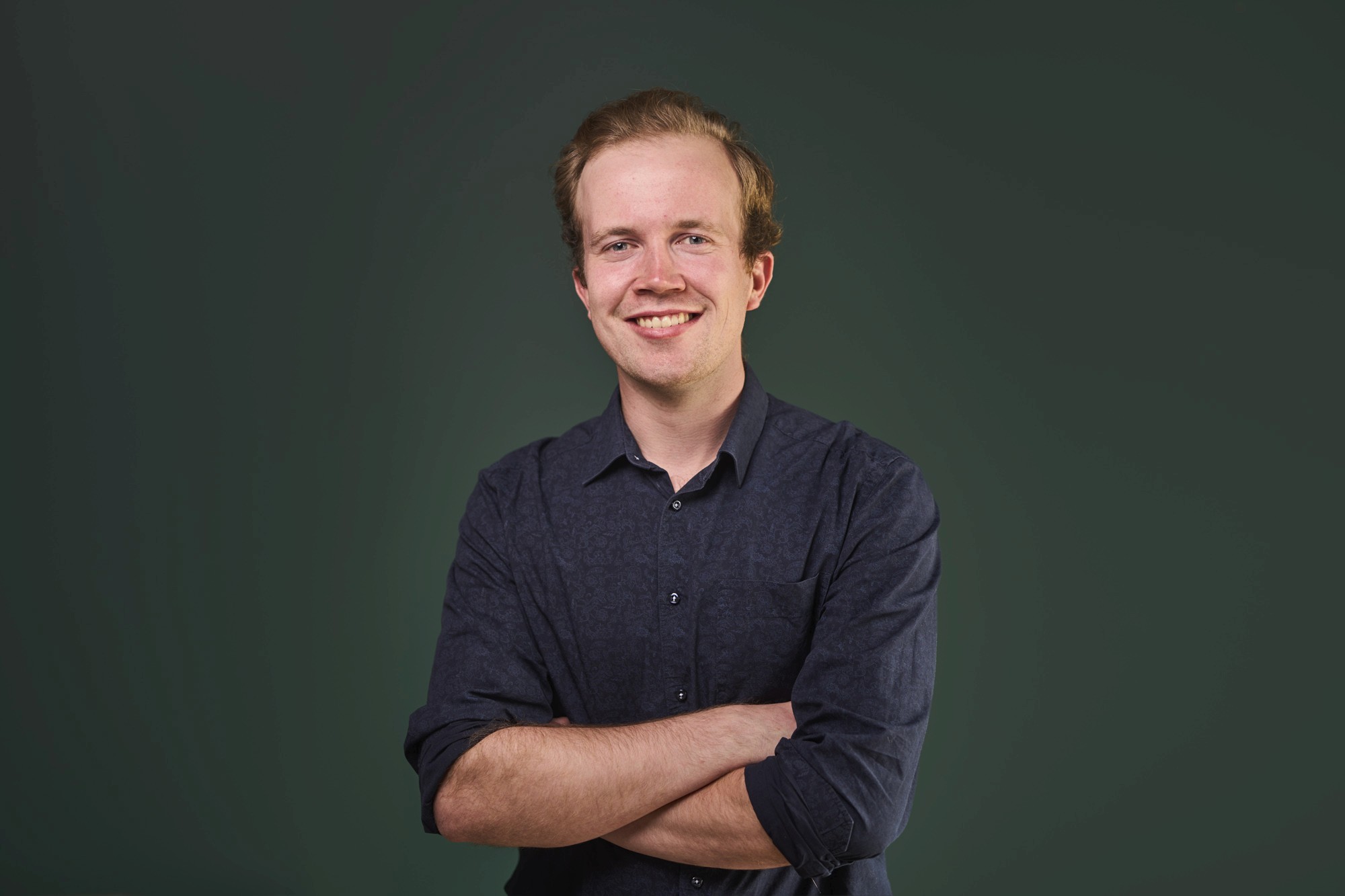 Close-up of a dark green leaf showing its textured surface and central vein against a muted background.