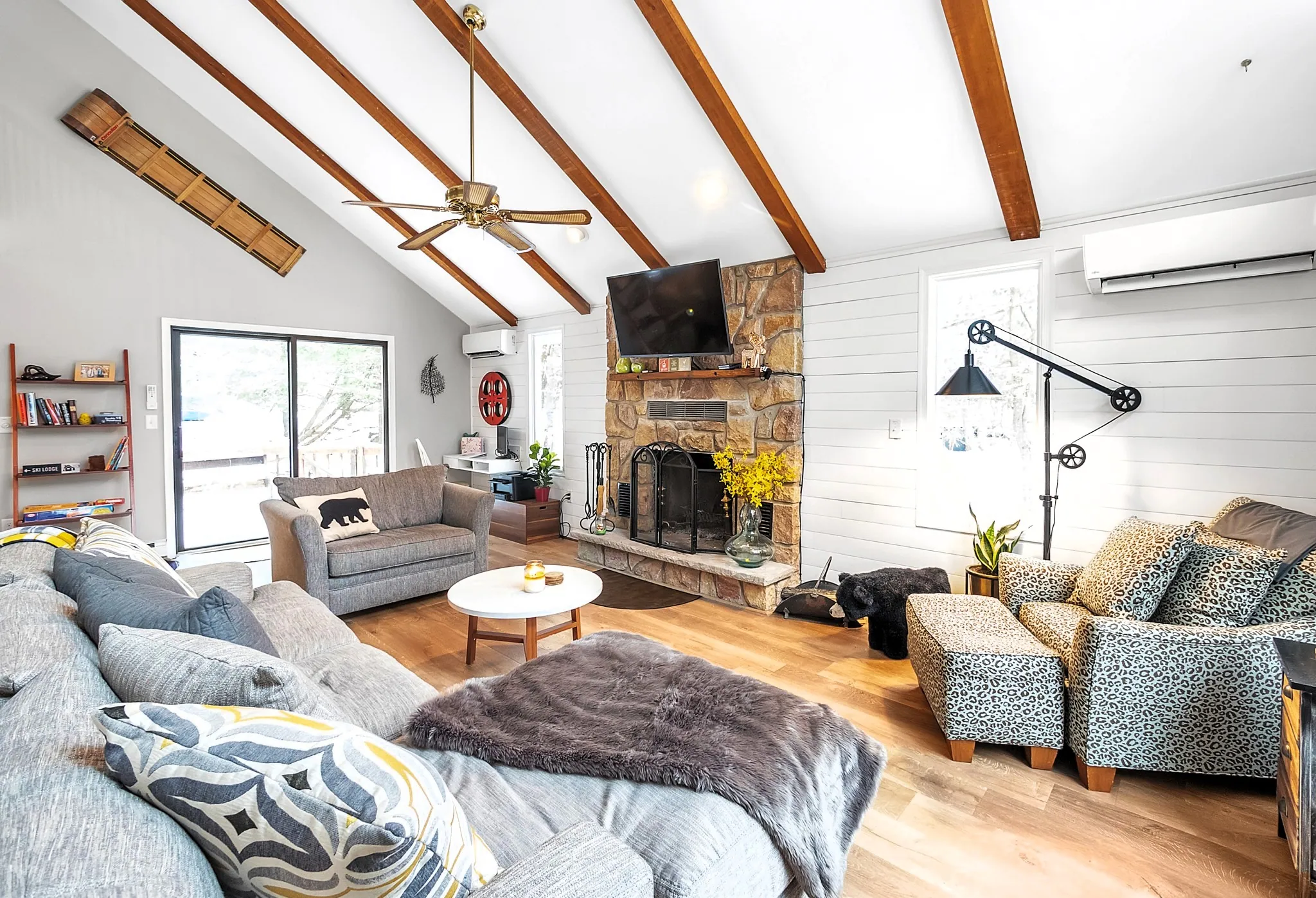 Bright living room with sectional, beamed vaulted ceiling and stone fireplace at Beechwood Bliss