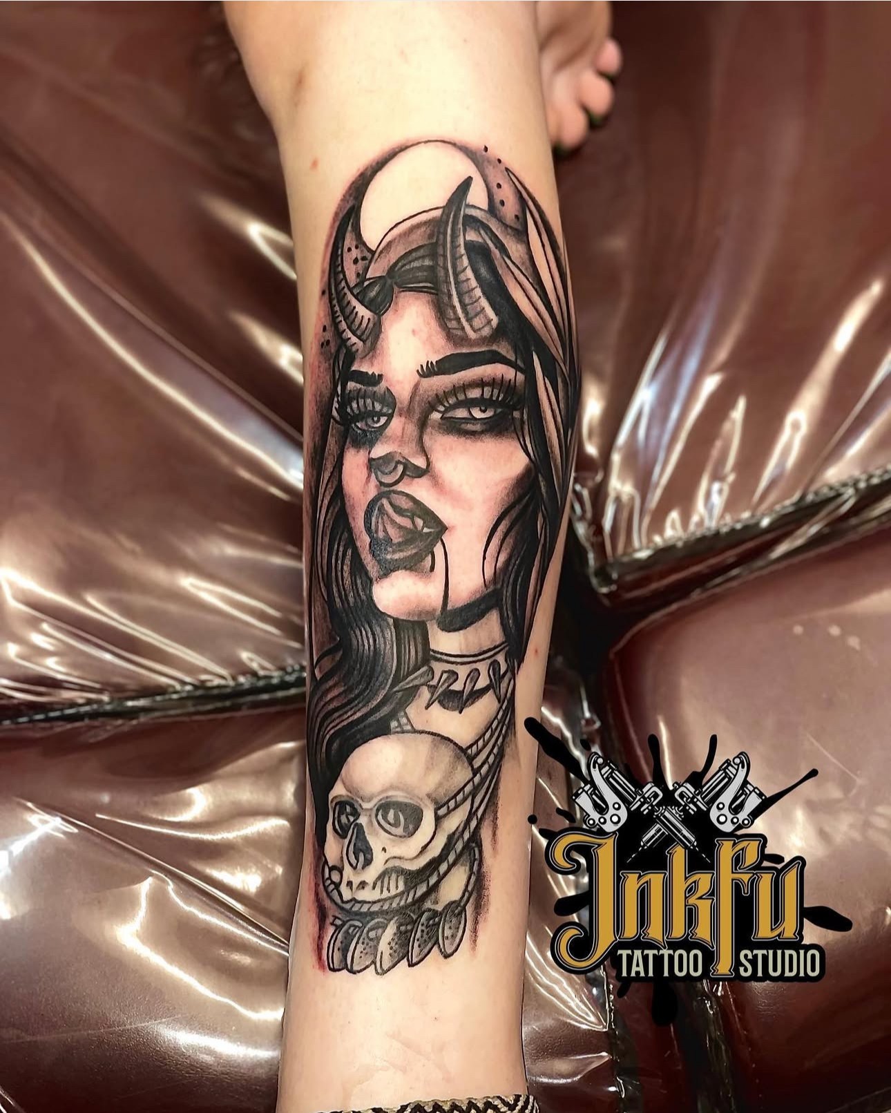 Black and grey neo-traditional tattoo of a devil woman and skull on the forearm, by Meer Rich