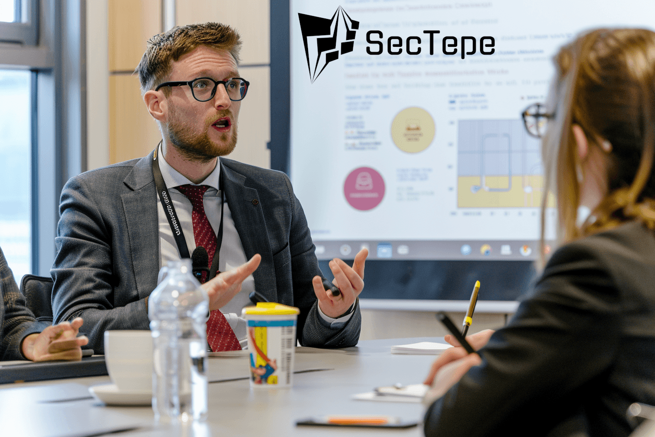 saubere Büroräume, professionell orientierte Erwachsene in Business-Kleidung nehmen aufmerksam an einer interaktiven Schulung teil, Infografiken auf dem Bildschirm zeigen die Einhaltung der DSGVO, Beispiele für Phishing-E-Mails, geöffnete Laptops mit IT-Modulen, warmes Tageslicht, Fotografie im Unternehmensstil, hochauflösende Aufnahme