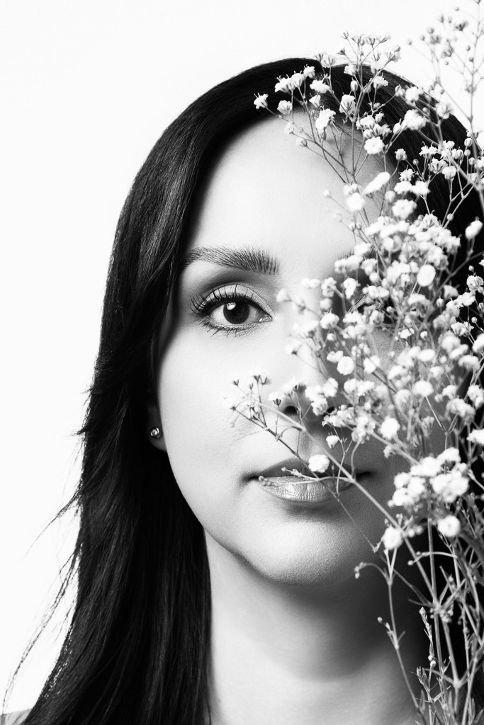 mujer en retrato femenino minimalista en estudio de fotografía con flores delicadas