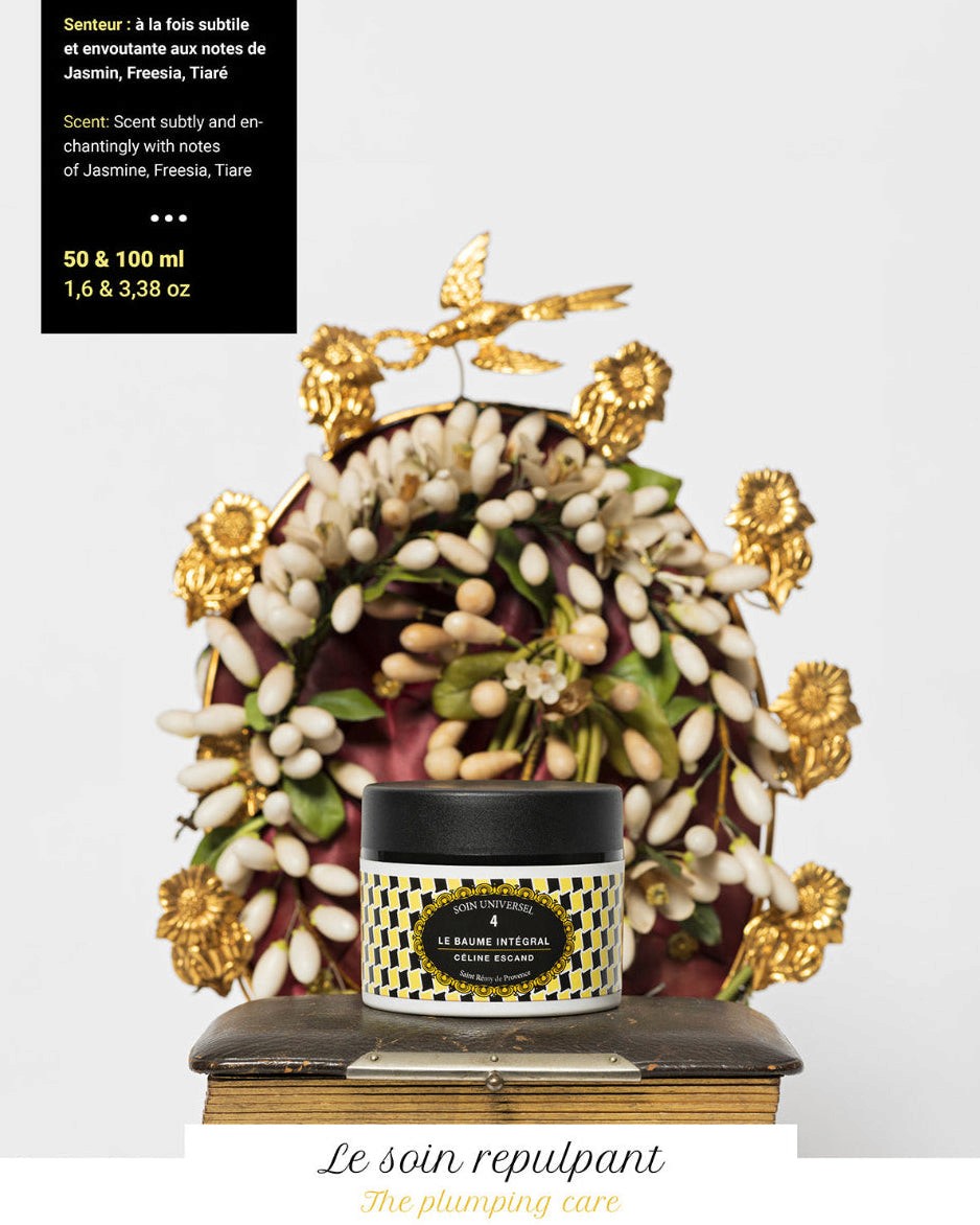 Pot n°4 du Baume Intégral Céline Escand, soin universel bio au parfum subtil et envoûtant de jasmin, freesia et tiaré, présenté devant une composition florale et dorée raffinée.