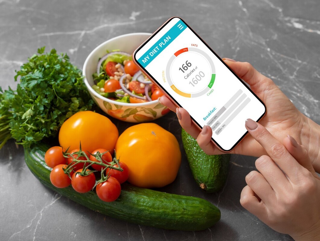 woman using a diet app on her phone to calculate the calories of a healthy salad to support her treadmill workout to lose weight