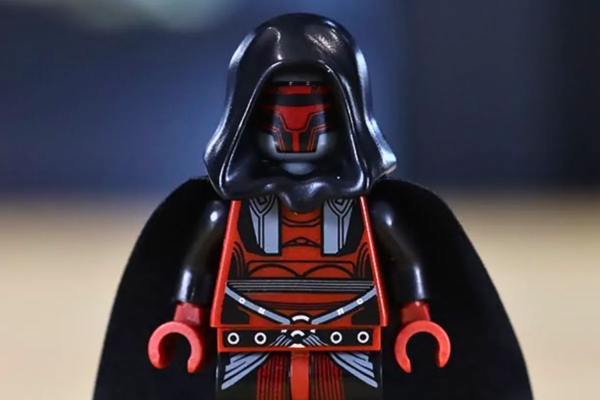 A close-up of the LEGO Darth Revan minifigure, featuring his signature red and black mask, dark hood, and detailed armor design. The minifigure includes intricate printing on the torso and legs, capturing Revan’s iconic appearance in a collectible form.