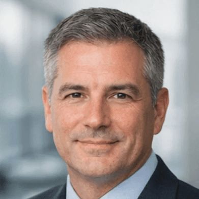 man wearing blue polo shirt with building background