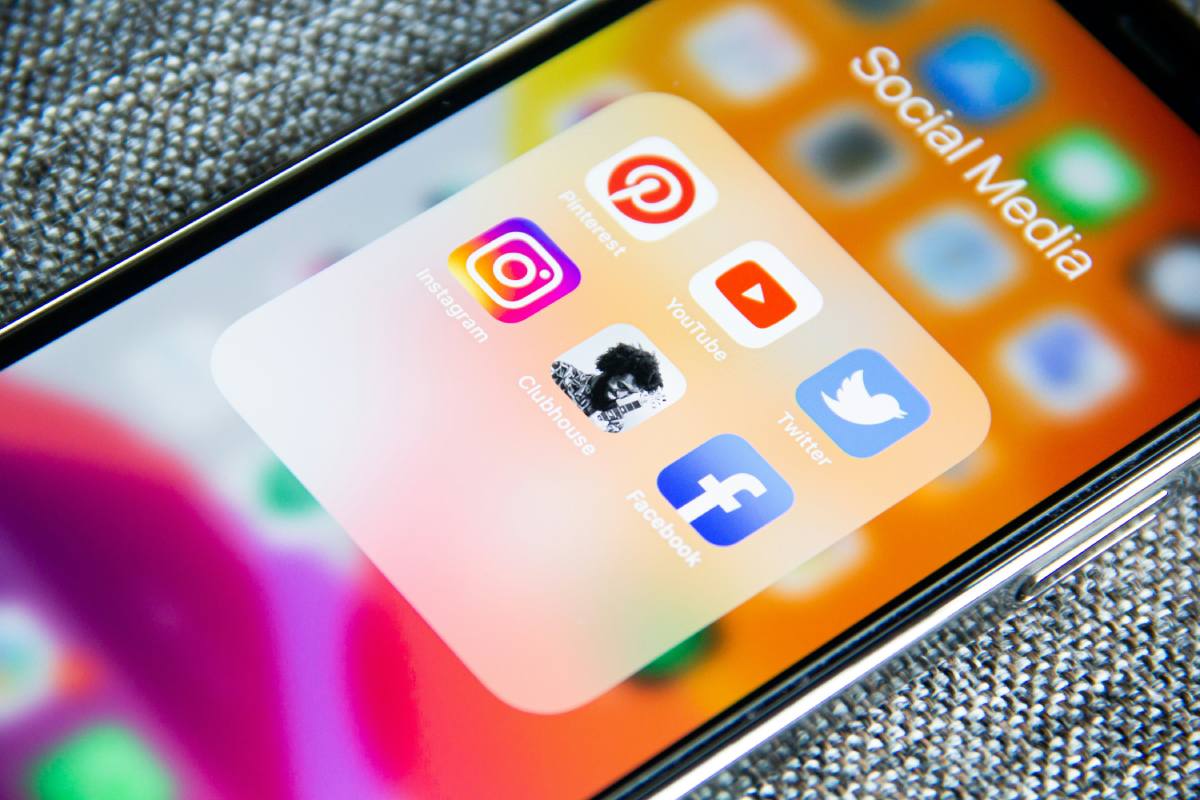 A phone with a folder open on social media apps, including Pinterest, Youtube, Twitter and more