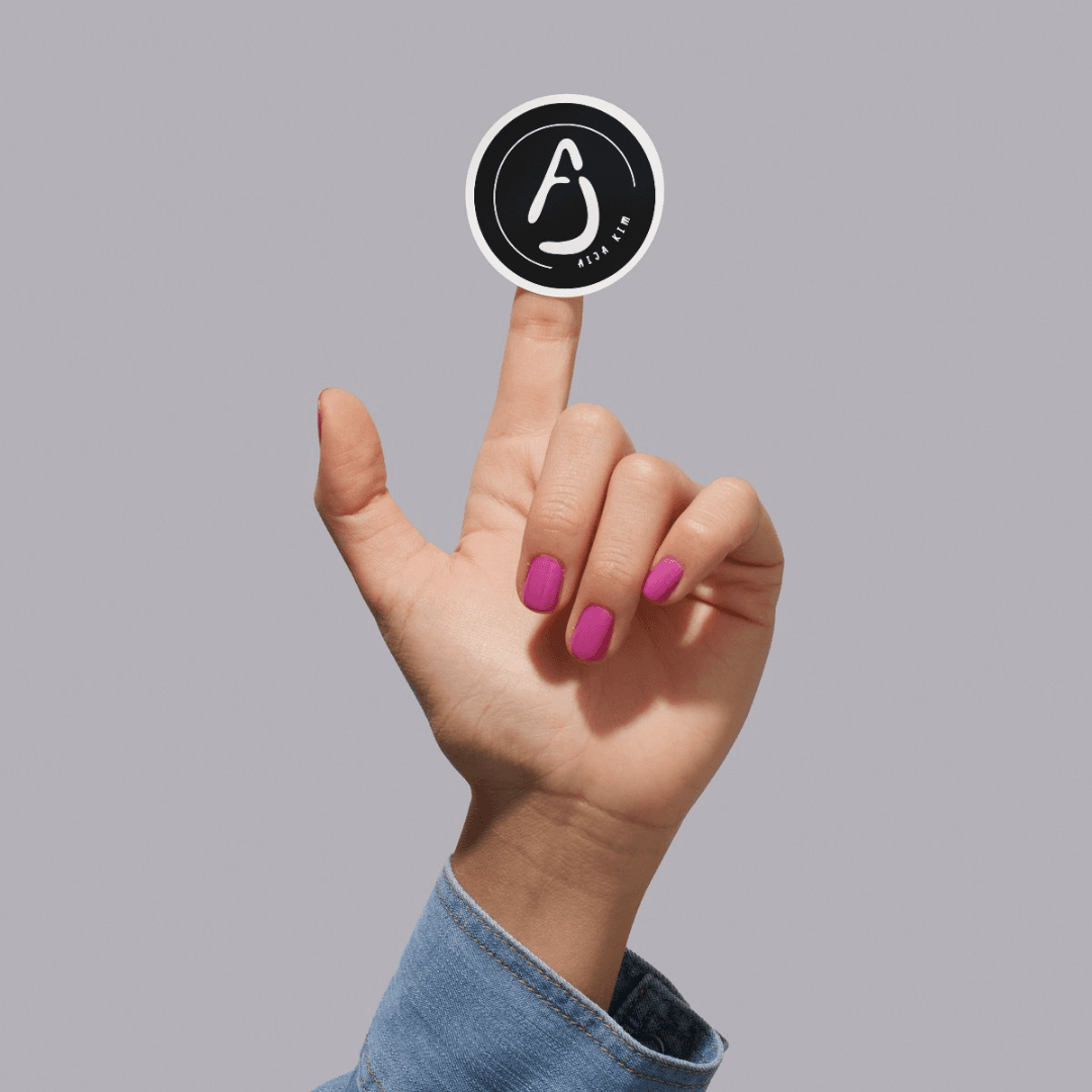 logo on sticker held up by female hand