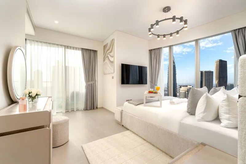 Bedroom with layered bedding and bedside lighting