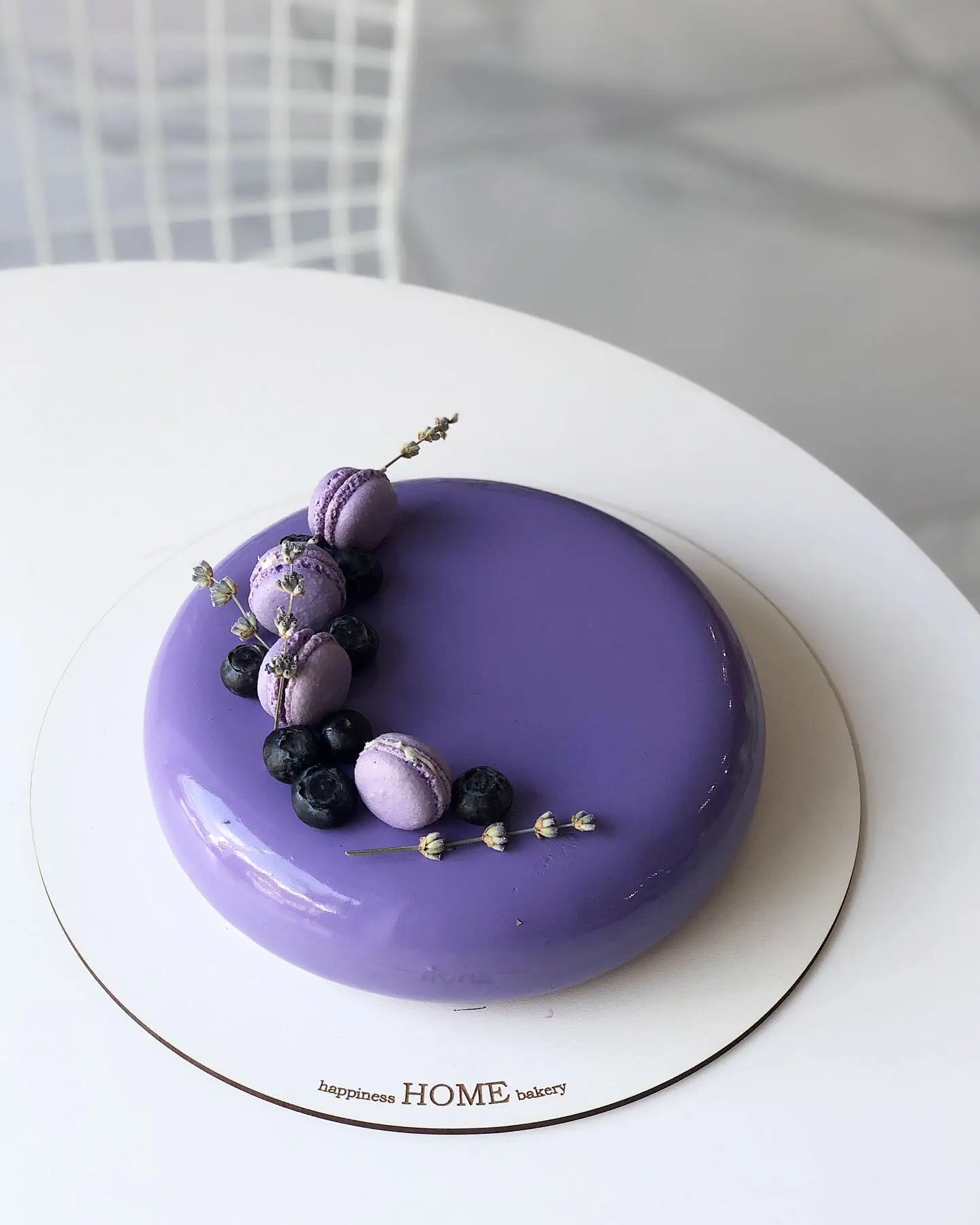 Purple dome-shaped cashew cake decorated with purple flowers and silver pearls