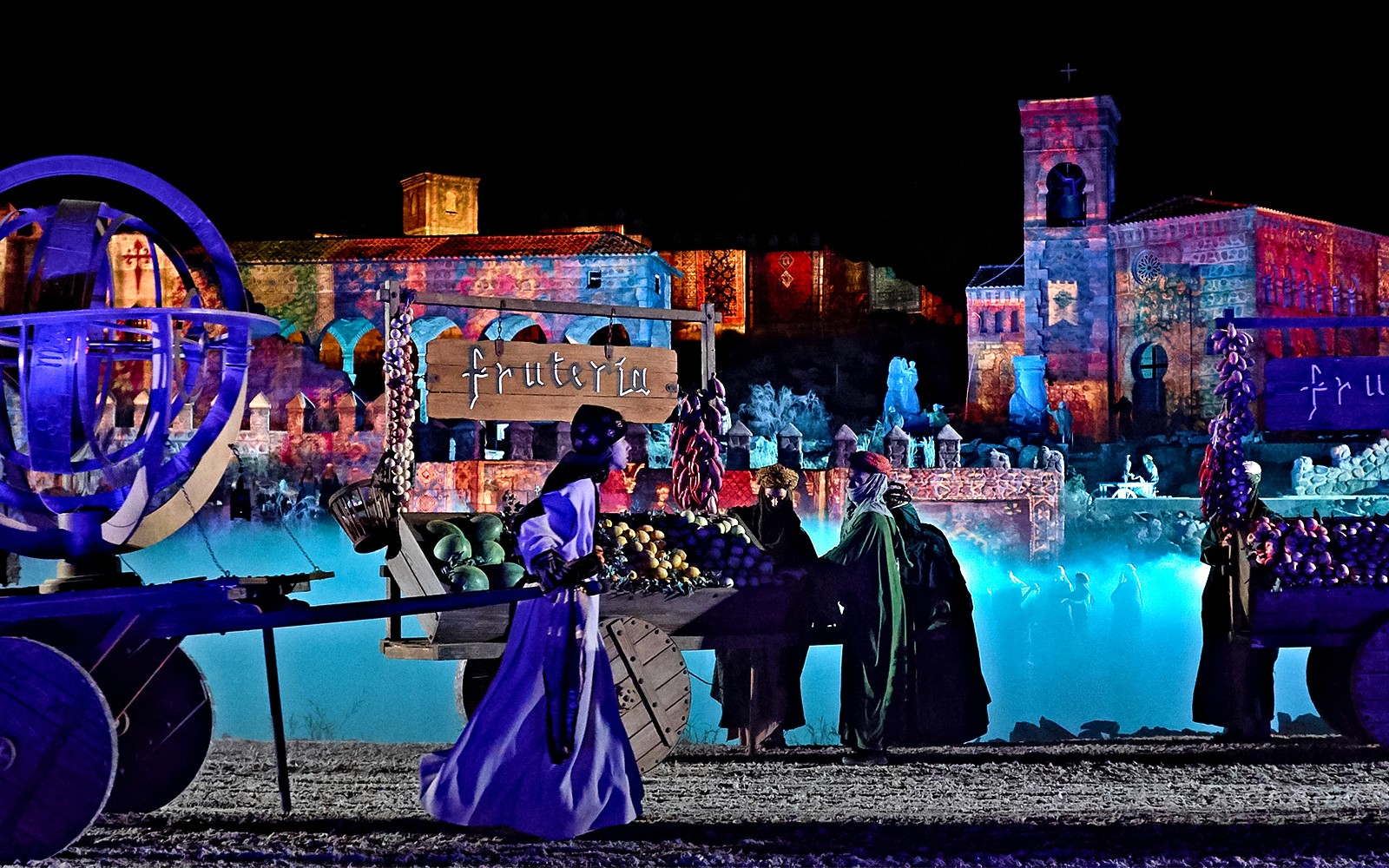 Espetáculo noturno em Toledo com artistas em trajes históricos no palco.