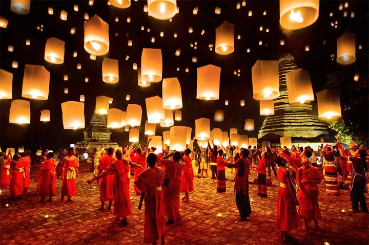 Buddhist monks lighting festival lanterns.