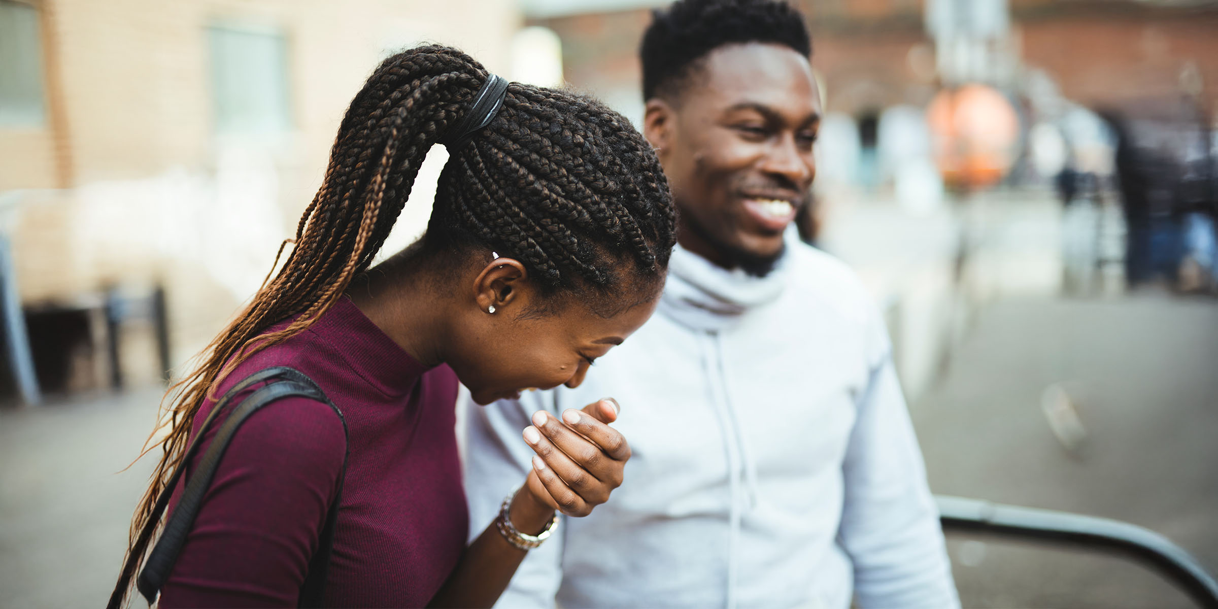 Two people laughing together outdoors, symbolising hope after homelessness