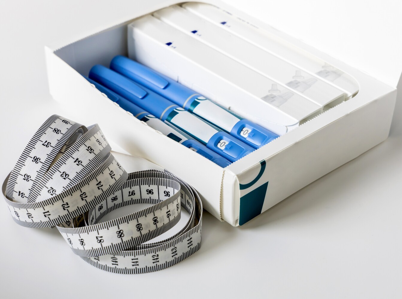 woman holding out an injection pen to show GLP-1 prescription meds for weight loss