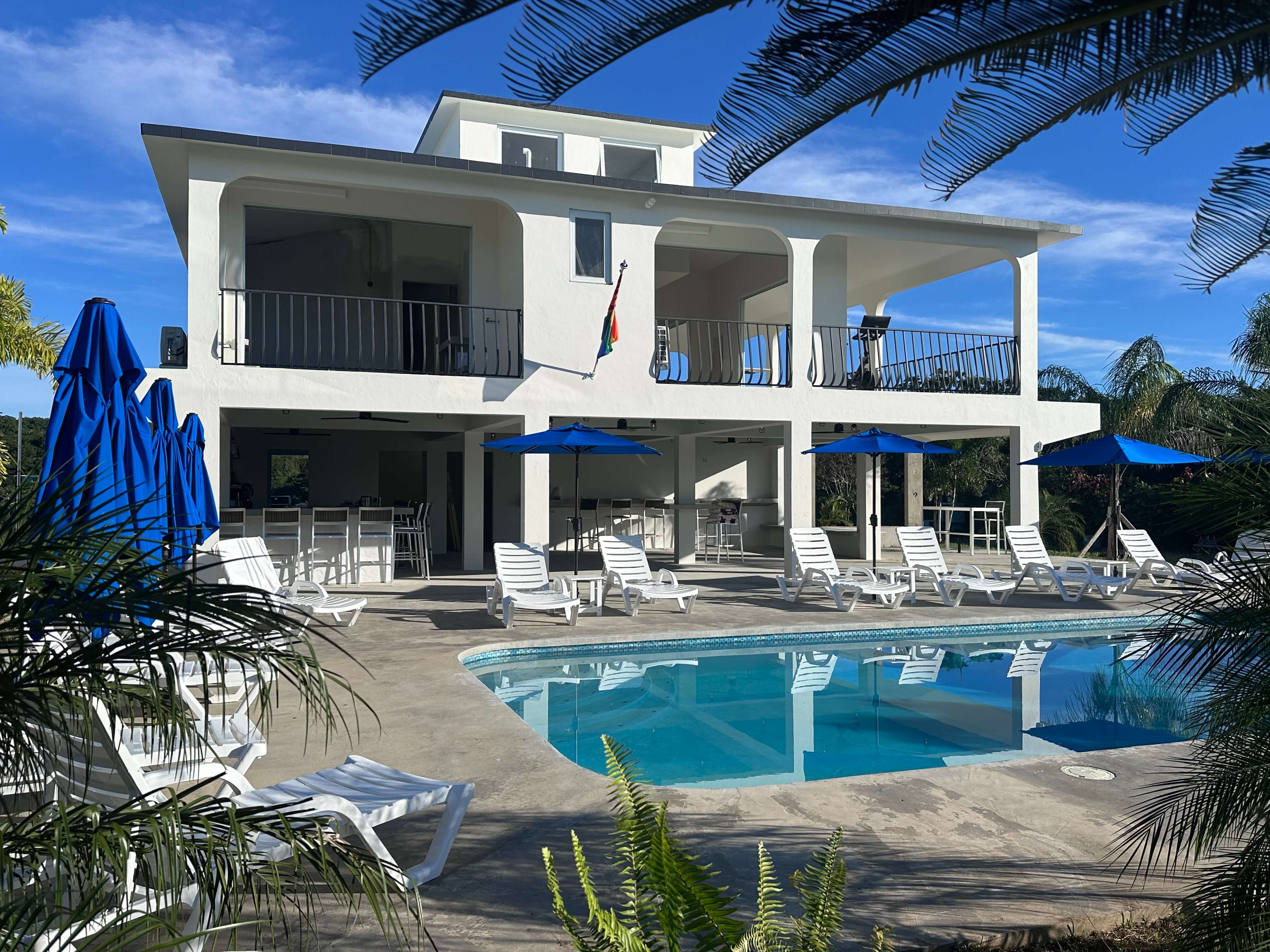 Pool at Club Vieques with loungers and umbrellas, offering stunning views of the Caribbean Sea, perfect for relaxing and unwinding.