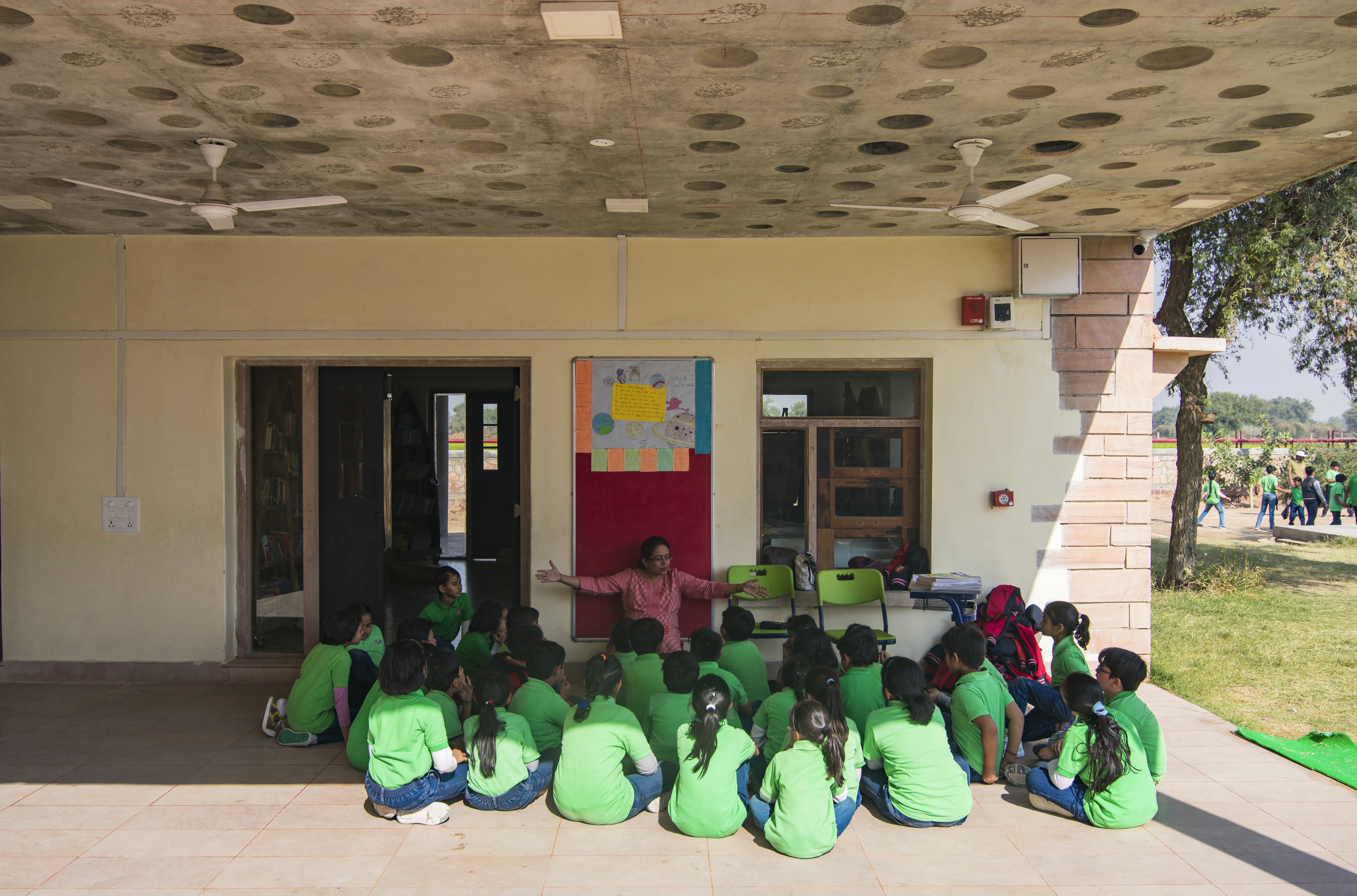 A cheerful student holds a tablet, smiling brightly
