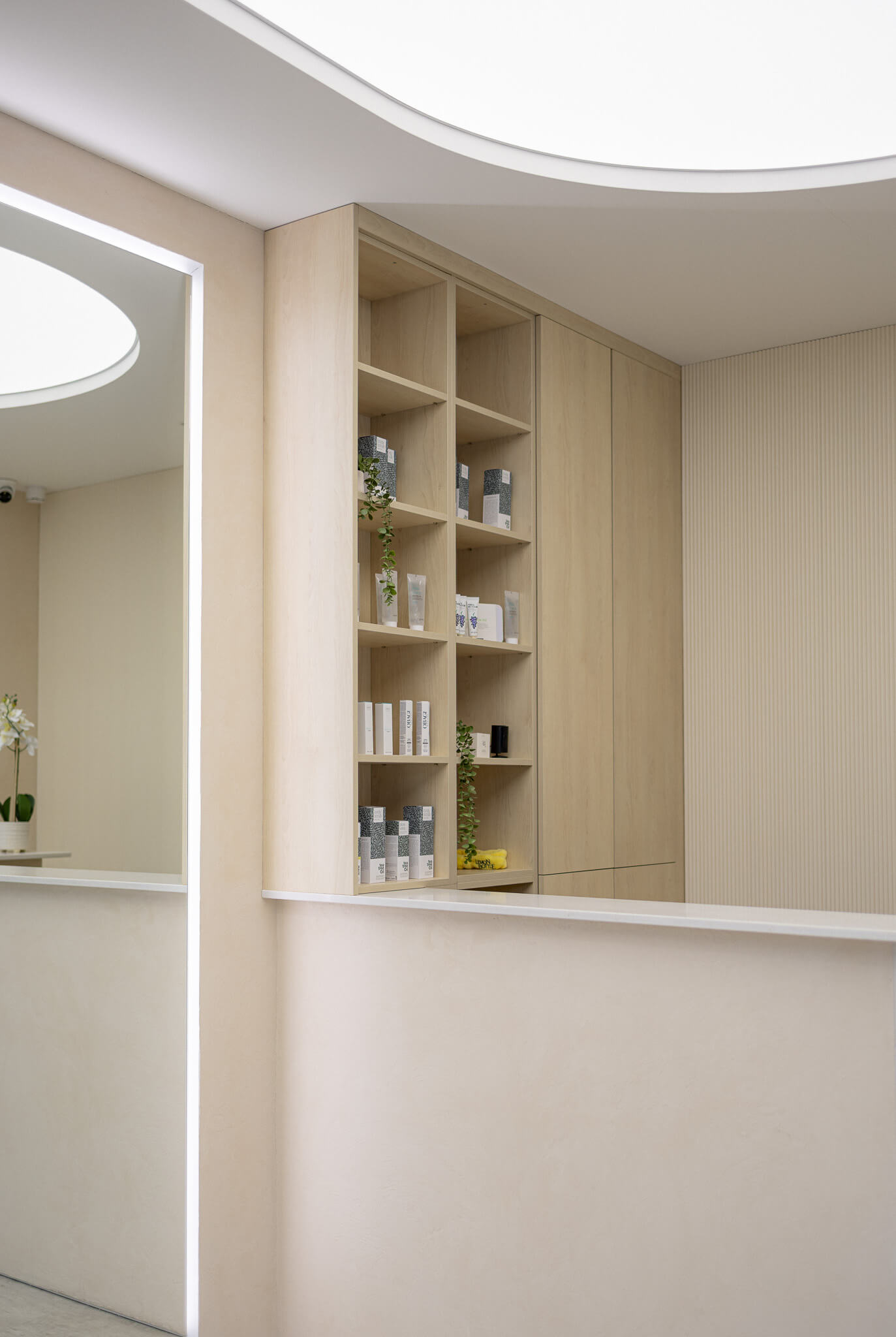 Reception area with skincare product shelves inside a modern aesthetic clinic.