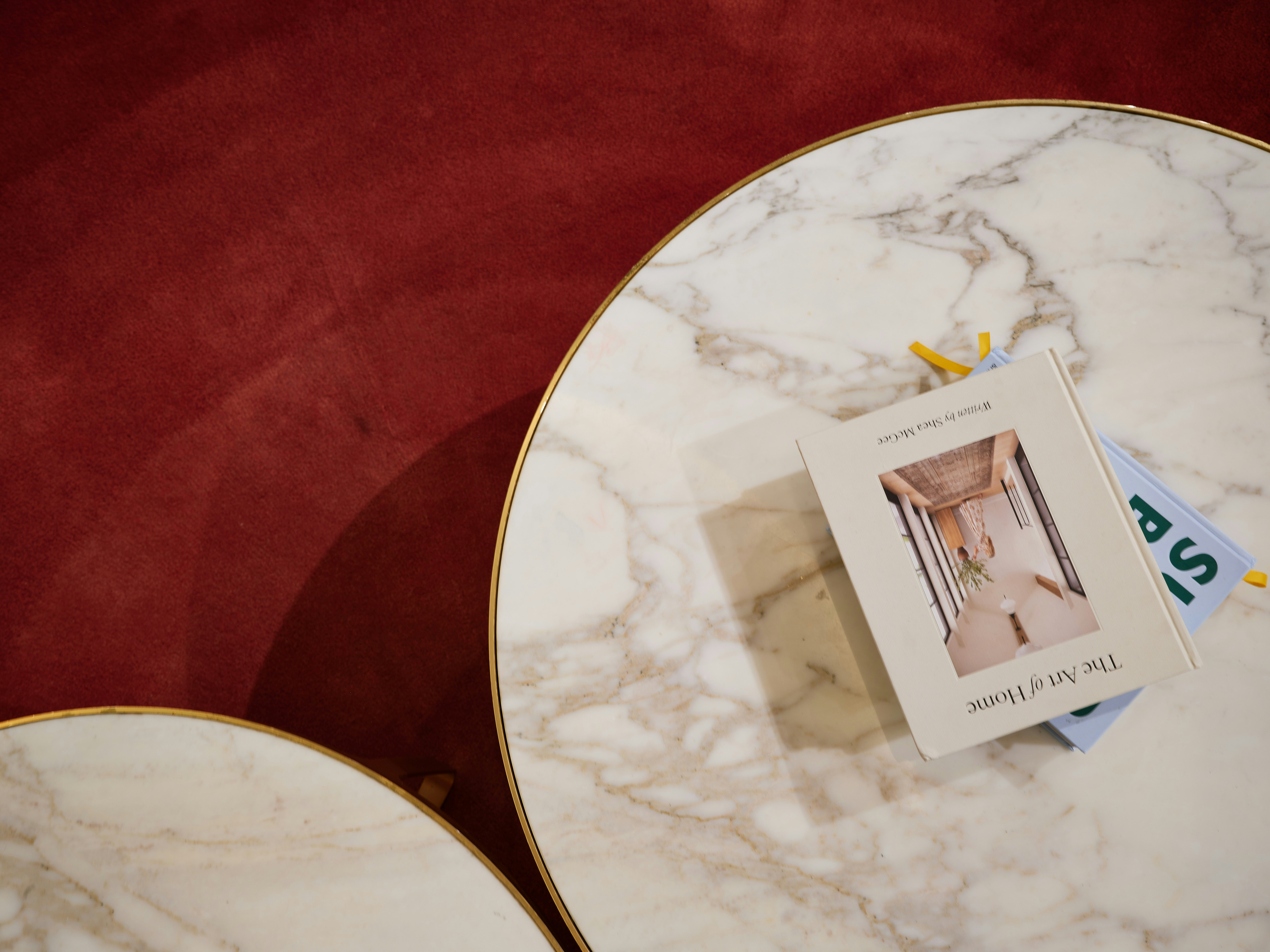 Two marble tables with a book on top.