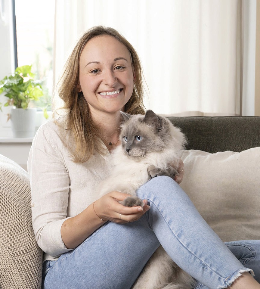 Nicole Rathmayr sitzt auf der Couch mit einer Katze