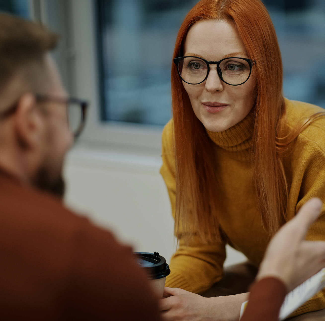 A woman and man facing each other in a conversation