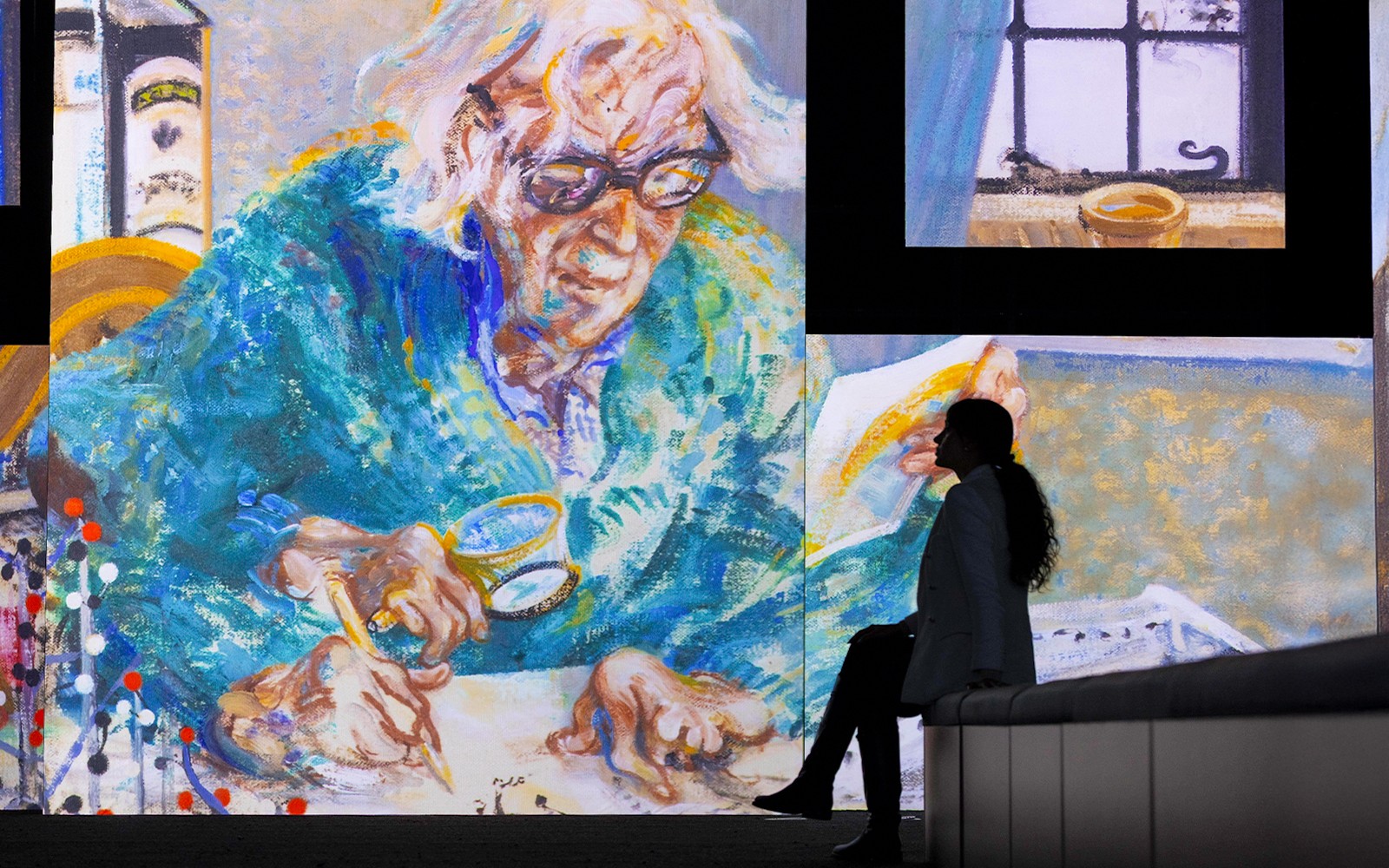 نمایشگاه بدون قاب گالری ملی پرتره شامل یک نقاشی بزرگ رنگارنگ از یک فرد مسن در حال نوشتن است.