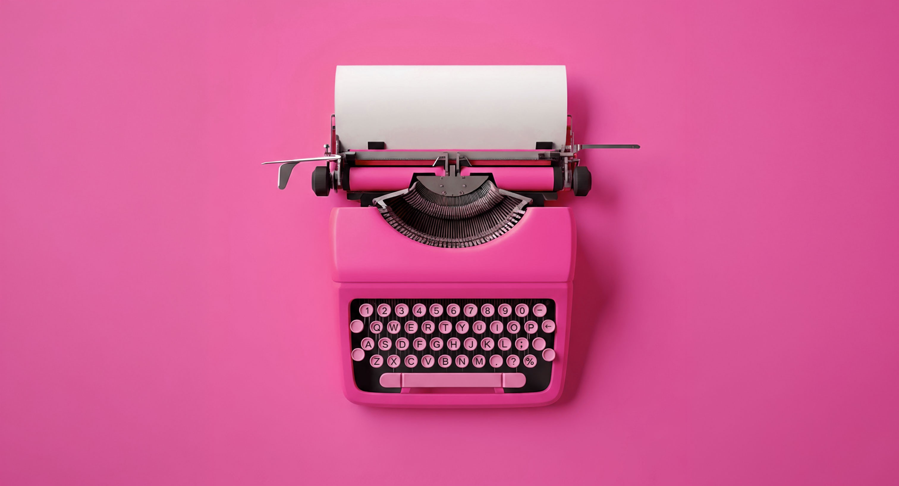 Pink typewriter with a blank sheet of paper, centered on a solid pink background