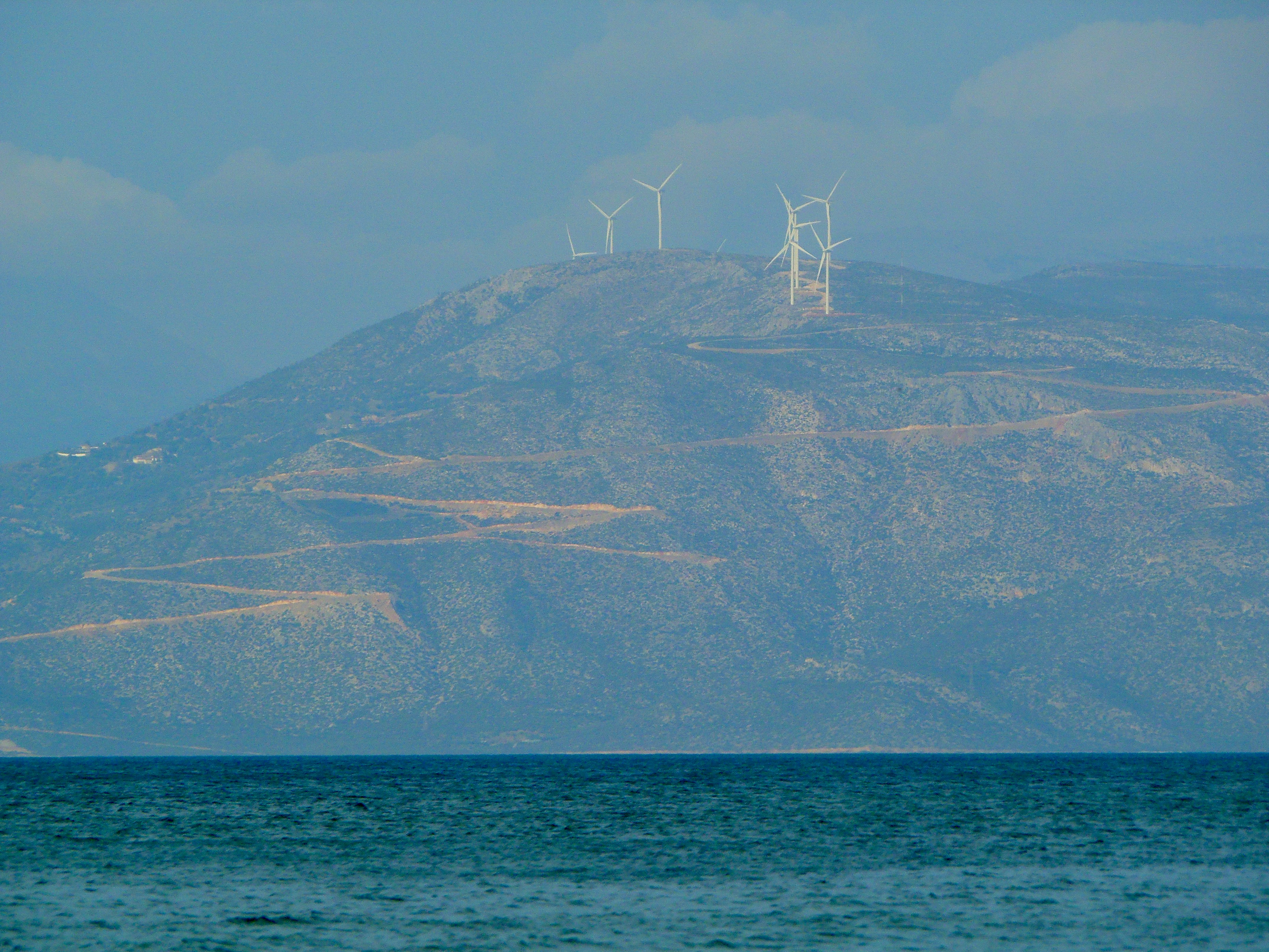 white sailboat on sea near mountain during daytime