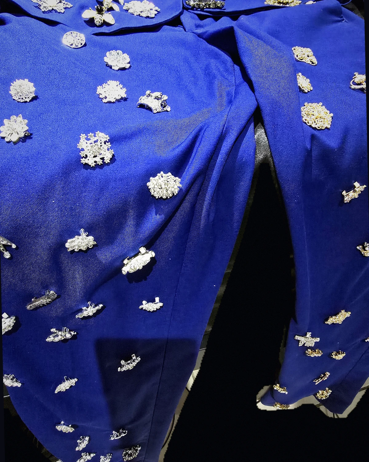Royal-blue Wonder Suit trousers and original brooches photographed with an early-digital direct-flash treatment.