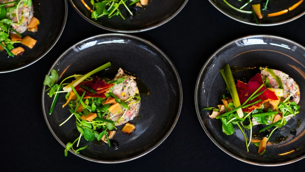 Overhead of chicken terrine plates on black linen
