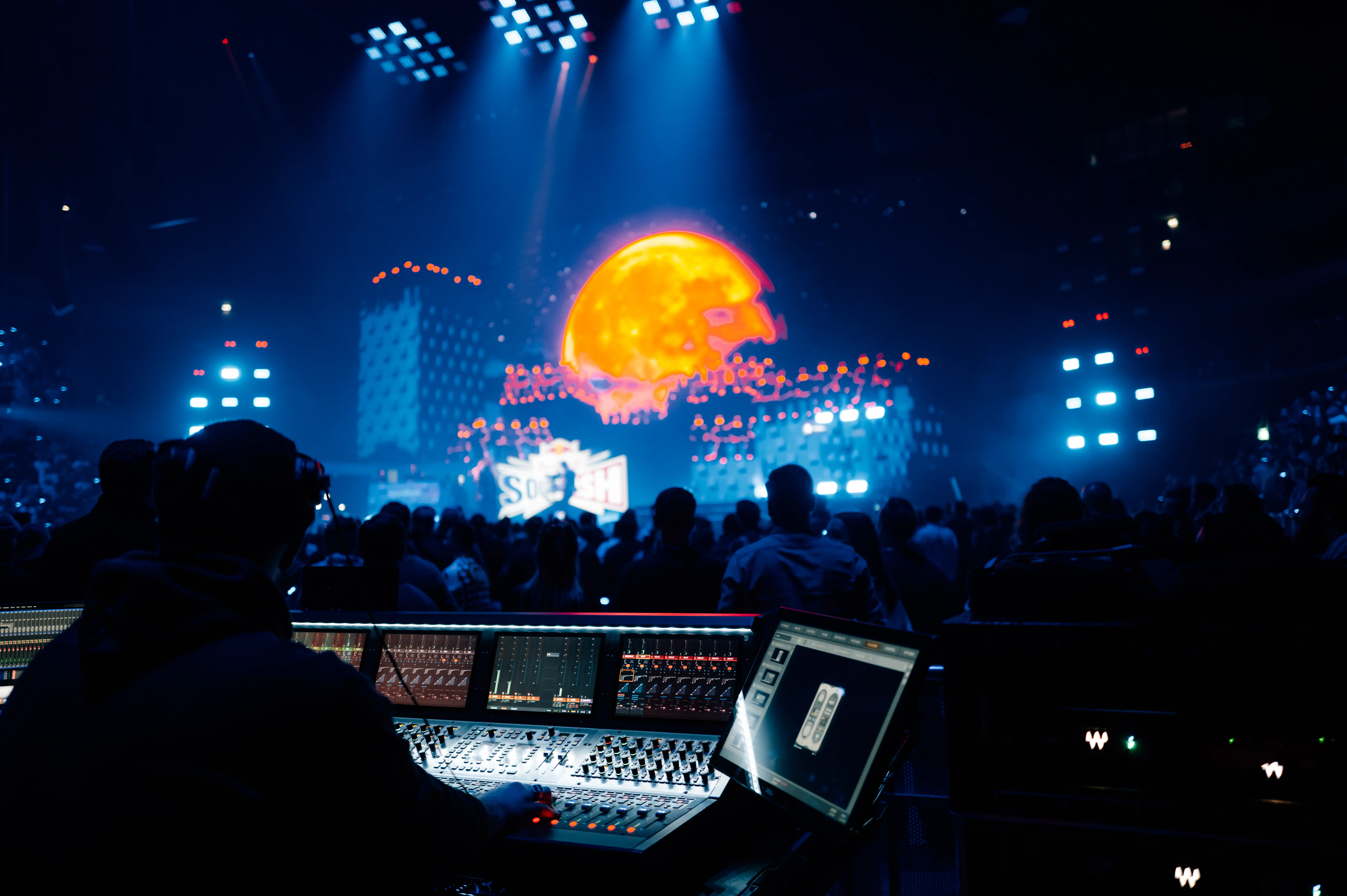 Live event production – technician at the mixing desk overlooking crowd and stage