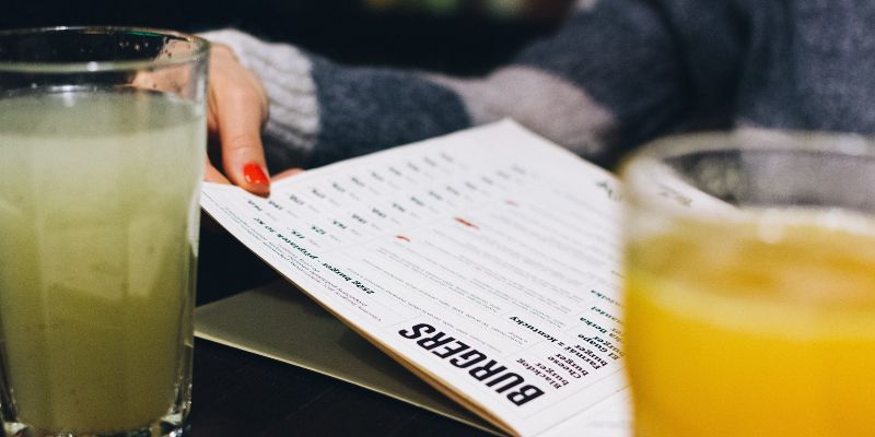 A customer looking through a menu at a restaurant