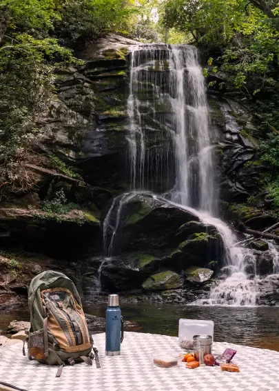 Picnic setup beside a forest waterfall