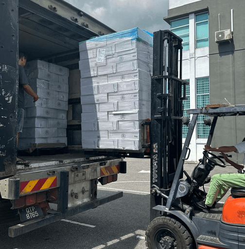 Loading flat-packed wholesale cake boxes into delivery lorry for daily shipping to Sibu, Miri, Bintulu and Sabah.