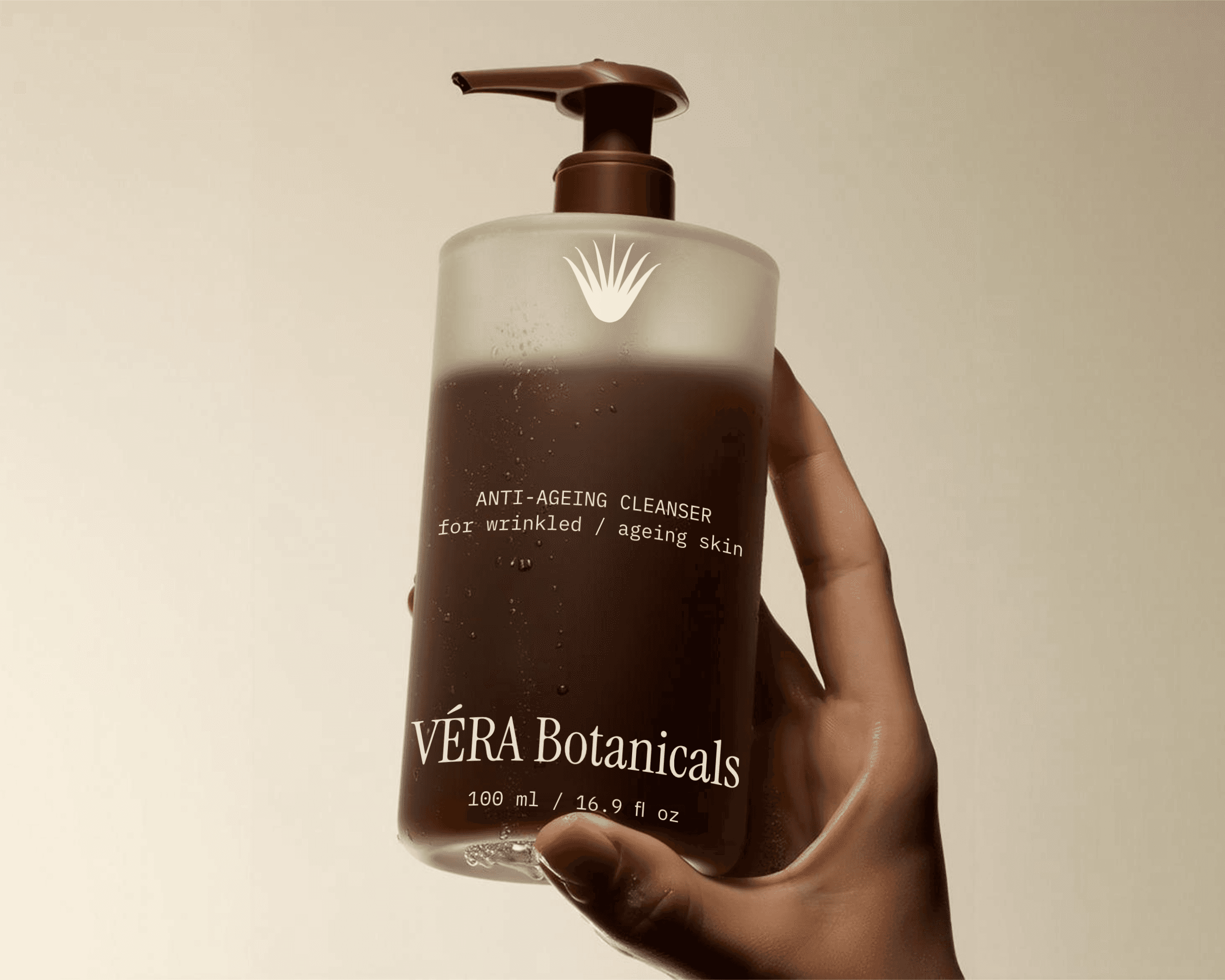 A packaging bottle design for the organic skincare brand VÉRA Botanicals. The bottle features a frosted glass finish with brown liquid inside.
