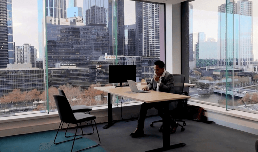 man sits at desk in high rise office building in city