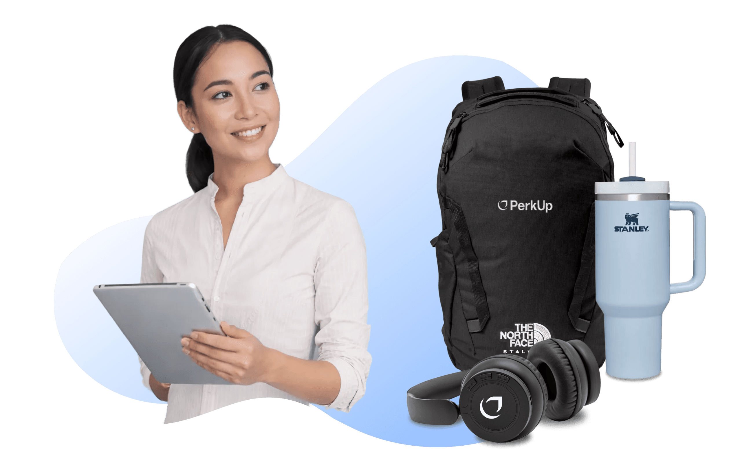 A woman holding a tablet. Beside her, there's a backpack, a headphone, and a Stanley tumbler.