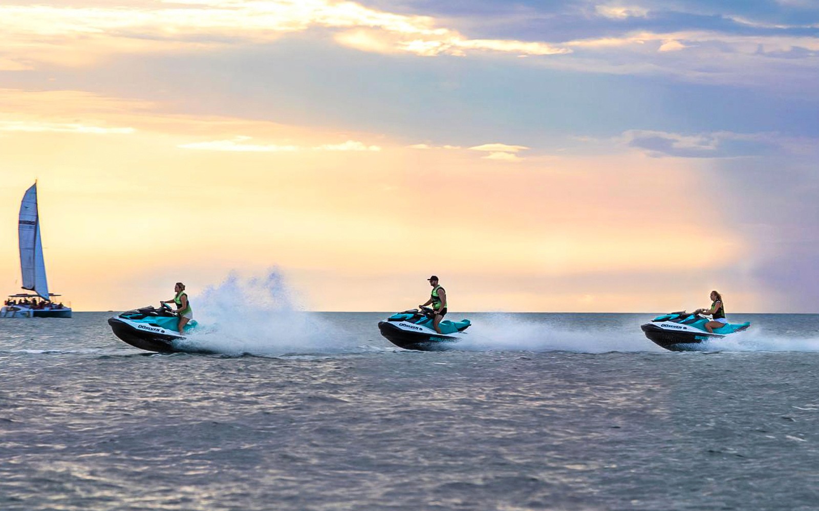 Jet skis speeding across the water at sunset during a tour in Darwin.