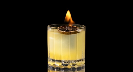 A closeup of a My Clementine drink against a dark background.